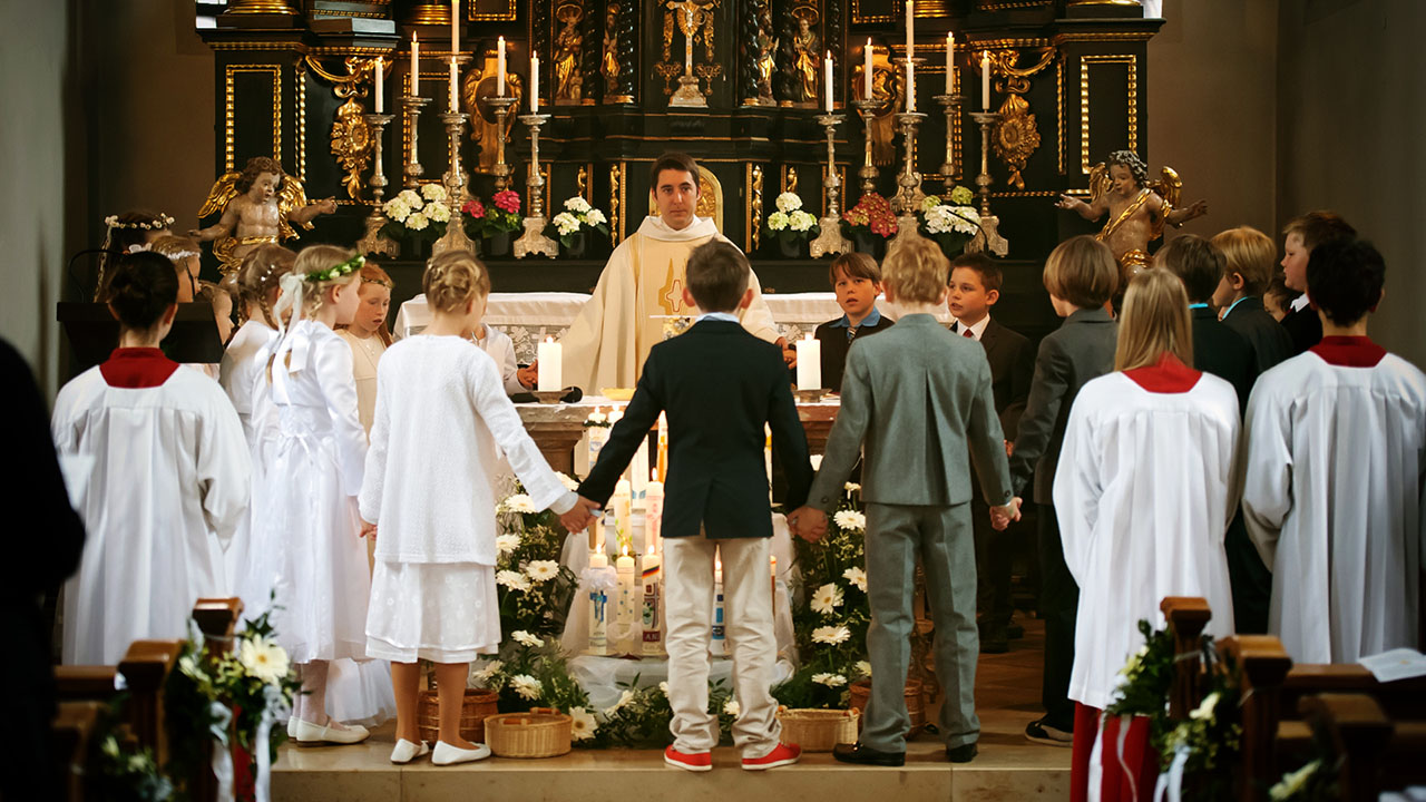 Reportage Kommunionskinder stehen im Gebet zusammen um den Altar