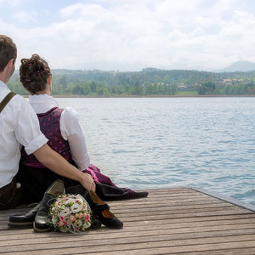Foto Weidner Hochzeitsfotos - Portraits vom Ehepaar auf einem Steg im Simssee und die Berge im Chiemgau im Hintergrund Hochzeitsfotos vom Ehepaar auf einem Steg im Simssee und die Berge im Chiemgau im Hintergrund